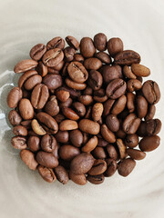 Bowl of coffee beans. beans are brown and have a lot of texture