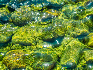 Beautiful Green Stones Under Clear Water. High-Resolution Image Ideal for Wallpapers, Digital Marketing, Social Media, and Nature-Inspired Creative Projects