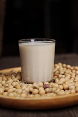 Soy milk with soybeans on wood background