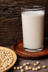 Soy milk with soybeans on wood background