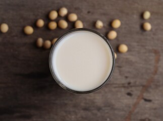 Soy milk with soybeans on wood background