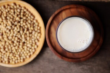 Soy milk with soybeans on wood background