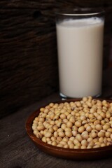 Soy milk with soybeans on wood background