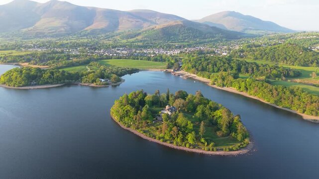 Aerial landscape footage above Keswick and Derwentwater lake with Derwent Isle prominent