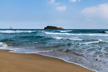 tranquil winter seascape with island and waves on the beach