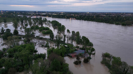 Aerial view of devastating river floodwaters submerging rural landscape and trees in Castelvetro Piacentino Italy during overcast weather conditions