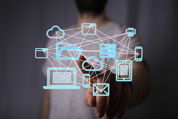 Image of a person interacting with a holographic network of devices, showcasing cloud computing and data connectivity.
