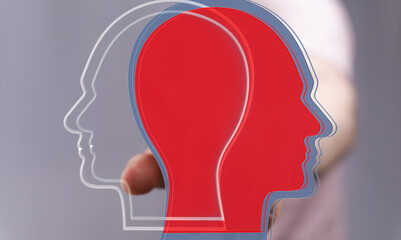 Stock photo depicting two overlapping head profiles, one red, one transparent, symbolizing duality and perspective.