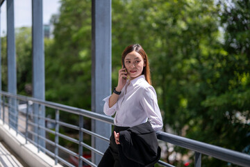 Obraz premium Businesswoman talking on phone on modern walkway