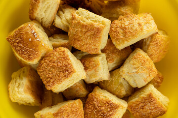 freshly baked cottage cheese scones topped with grated cheese in yellow bowl