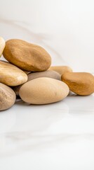 Aesthetic Composition of Smooth, Earth-Toned River Stones on a Pristine White Surface,