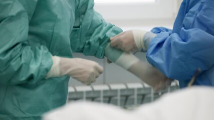 Close-up of a surgeon putting on gloves before surgery. Concept preparing the surgeon for a sterile surgical procedure. - Powered by Adobe