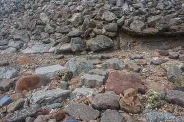 Rocks on the beach, Koh Larn, Thailand. A collection of assorted rocks and stones lies scattered on a sandy beach. 