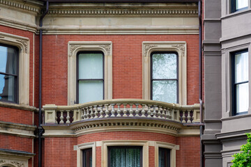 Detailed view of ornate balcony and red-brick townhouse facade in Boston, Massachusetts, USA