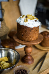 Traditional Easter cakes (kulich) with icing, dried fruits, and nuts on rustic background. Homemade sweet bread, festive pastry for Orthodox Easter, decorated with eggs and spring details.