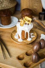 Traditional Easter cakes (kulich) with icing, dried fruits, and nuts on rustic background. Homemade sweet bread, festive pastry for Orthodox Easter, decorated with eggs and spring details.