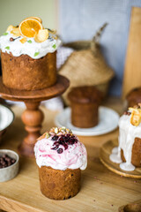 Traditional Easter cakes (kulich) with icing, dried fruits, and nuts on rustic background. Homemade sweet bread, festive pastry for Orthodox Easter, decorated with eggs and spring details.