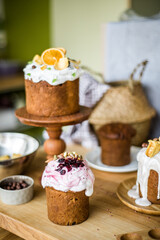 Traditional Easter cakes (kulich) with icing, dried fruits, and nuts on rustic background. Homemade sweet bread, festive pastry for Orthodox Easter, decorated with eggs and spring details.