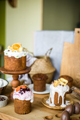Traditional Easter cakes (kulich) with icing, dried fruits, and nuts on rustic background. Homemade sweet bread, festive pastry for Orthodox Easter, decorated with eggs and spring details.