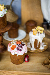 Traditional Easter cakes (kulich) with icing, dried fruits, and nuts on rustic background. Homemade sweet bread, festive pastry for Orthodox Easter, decorated with eggs and spring details.