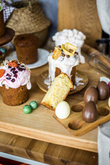 Fototapeta premium Traditional Easter cakes (kulich) with icing, dried fruits, and nuts on rustic background. Homemade sweet bread, festive pastry for Orthodox Easter, decorated with eggs and spring details.