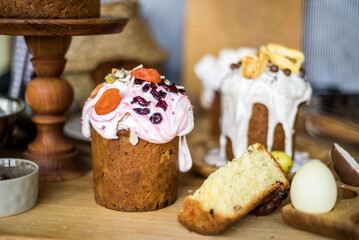 Traditional Easter cakes (kulich) with icing, dried fruits, and nuts on rustic background. Homemade sweet bread, festive pastry for Orthodox Easter, decorated with eggs and spring details.