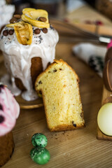 Traditional Easter cakes (kulich) with icing, dried fruits, and nuts on rustic background. Homemade sweet bread, festive pastry for Orthodox Easter, decorated with eggs and spring details.