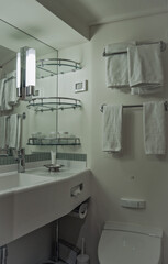 Elegant ocean view marble bathroom spa wellness area inside luxury suite with loungers, bath tub, sink, towels and amenities	