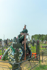 Fototapeta premium A tranquil wagtail perched on a memorial cross symbolizing hope and remembrance surrounded by vibrant flowers reflecting the beauty of life. Flowers on a grave.