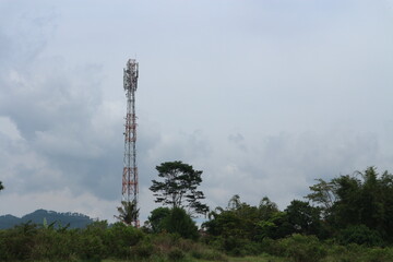 Communication Tower in Countryside Tall communication tower standing among rural trees.