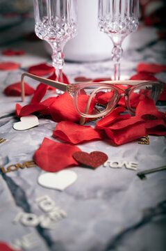 A pair of corrective eyeglasses resting on red rose petals, ideal for Valentine&rsquo;s Day, eye care