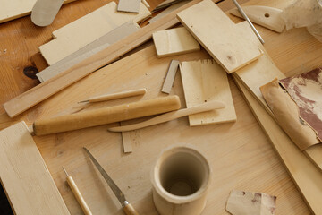 High-angle view of various woodworking tools and materials scattered on a wooden table.