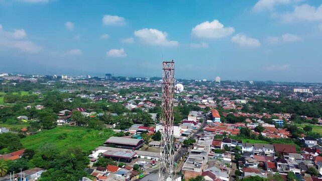 A telecommunications tower in a densely populated area. 4G and 5G cellular telecommunications towers. Base Transceiver Station. Wireless Communication Tower. Telecommunication background video.