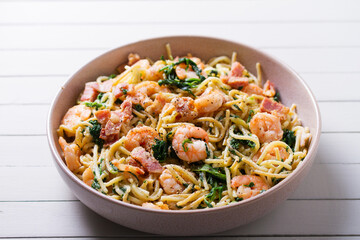 Seafood pasta with spinach and bacon. Spaghetti with shrimps