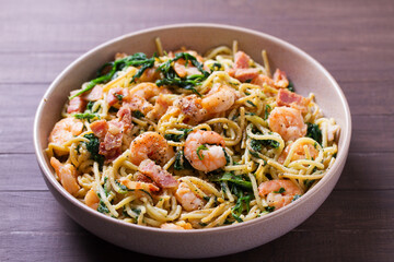 Seafood pasta with spinach and bacon. Spaghetti with shrimps