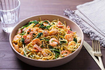 Seafood pasta with spinach and bacon. Spaghetti with shrimps