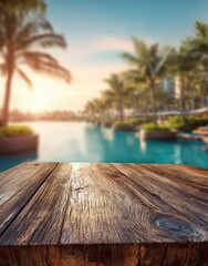 Obraz premium Wooden table top with a blurred tropical hotel swimming pool at sunset, ideal for product display in a luxurious beach resort setting.