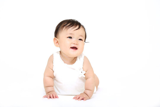 白背景の前をハイハイする赤ちゃんの正面クローズアップ