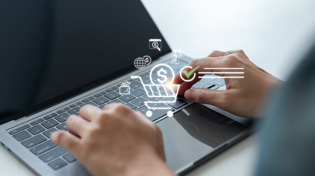 Close-up of hands typing on a laptop keyboard with shopping cart and payment icons. Concept of e-commerce transaction, online checkout, digital finance, secure payment, and virtual retail shopping.