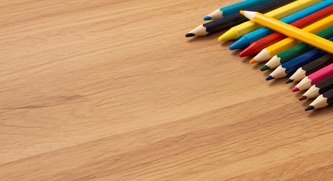 A rainbow of colored pencils arranged on a wooden table, perfect for a school or art project. - Powered by Adobe