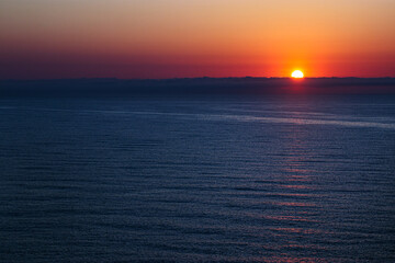 Sunrise in Catalan country, at Cap Béar, reflected in the sea surrounded by rocks at Port Vendres in the south of France. 
