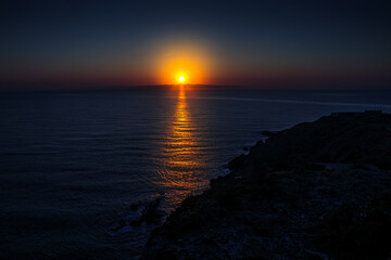 Fototapeta premium Sunrise in Catalan country, at Cap Béar, reflected in the sea surrounded by rocks at Port Vendres in the south of France. 