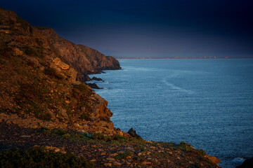 Sunrise in Catalan country, at Cap Béar, reflected in the sea surrounded by rocks at Port Vendres in the south of France. 
