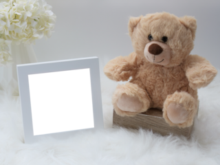 Child's stuffed beige teddy bear toy with white photo picture transparent frame on a dreamy fluffy soft fur rug with cream white hydrangea flower blossom. Customize with your own photo image or video.