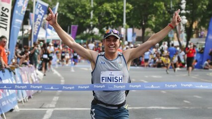 Marathon Runner Triumphantly Crosses Finish Line
