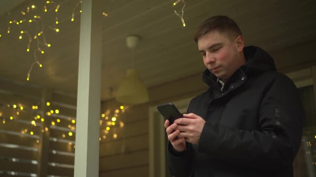 a young man is using his smartphone outdoors