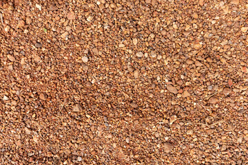 Closeup natural texture of small brown sand, stones, and pebbles on a beach
