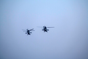 Military helicopter air attack by a squadron isolated on blue sky