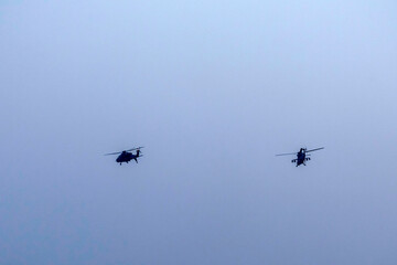 Military helicopter air attack by a squadron isolated on blue sky