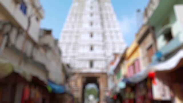 Bokeh view of devotees visit Sri Govinda Raja Swamy Temple in Tirupati, India. Blurred background footage.